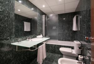 托尔托萨贝伦格尔四世酒店的一间带水槽、卫生间和镜子的浴室