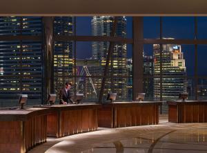 吉隆坡吉隆坡君悦酒店的坐在一张桌子上,坐在城市天际线的大房间里