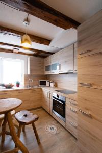 格平根Appartamenti Quattro Ducati的厨房配有木制橱柜、木桌和桌子。