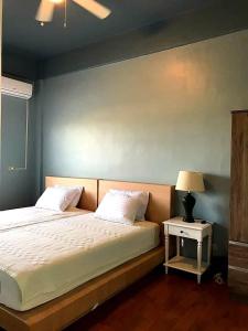 San Vicentelee's home2的一间卧室配有一张床和一个带灯的床头柜