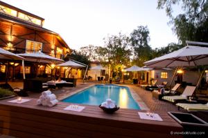 温特和克非洲屋顶酒店的一个带桌子和遮阳伞的酒店游泳池