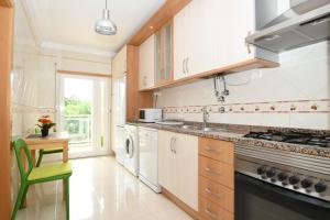 波尔蒂芒Apartamento Vila Arade的厨房配有水槽和炉灶 顶部烤箱