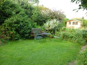 卡恩Calne Bed and Breakfast的草地上带桌椅的花园