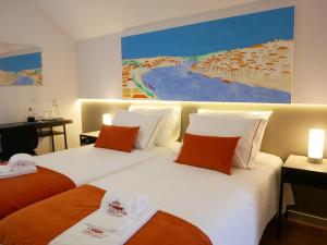 加亚新城Serra do Pilar Porto Suites的两张位于酒店客房的床,墙上挂着一幅画