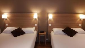 第戎蒙特沙佩第戎中心酒店的两张睡床彼此相邻,位于一个房间里