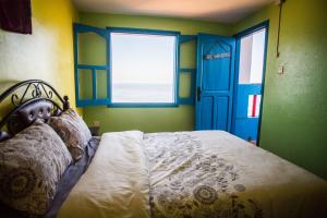 西迪伊夫尼Auberge Maison Diyani的一间卧室配有一张带蓝色门和窗户的床