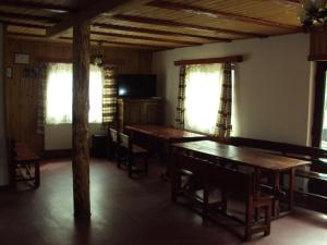 Rau SaduluiComplex turistic Nora Rau Sadului的用餐室设有木桌、椅子和窗户。