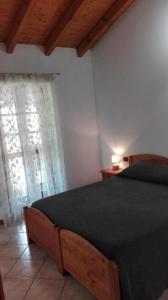 Osmate LentateAgriturismo Pastorelli的一间卧室配有一张带黑色棉被的床和窗户。
