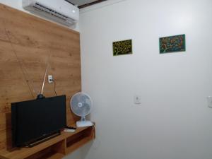 圣塔伦Imóveis Por Temporada em Santarém no Pará的一间带电视和风扇的客厅
