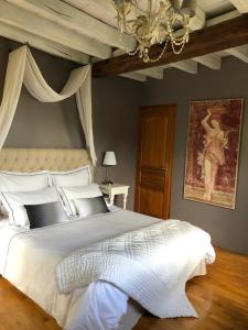 Saché雪弗里艾磨坊住宿加早餐旅馆的卧室配有一张白色大床和吊灯。