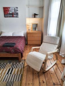 伦敦Home In Queen's Park的一间卧室配有一张床和一把椅子