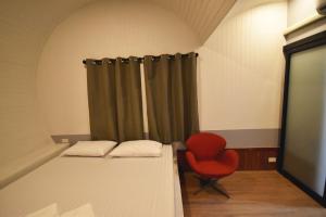 曼谷Tiny hut resort的一间设有两张床和红色椅子的房间