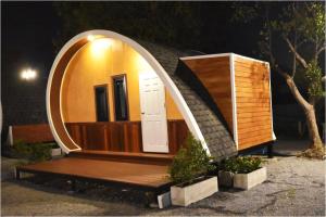 曼谷Tiny hut resort的一座带圆门和木凳的小房子