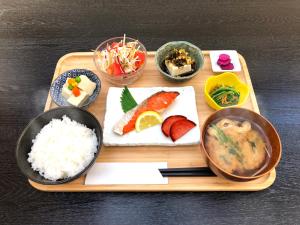 大阪大阪胶囊旅馆（仅限男性）的盘子上放着米饭和不同种类的食物