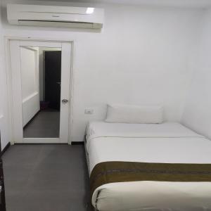 吉隆坡Swiss Hotel Kuala Lumpur的一间白色客房,设有两张床和门廊