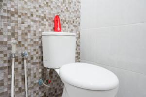 直葛RedDoorz near Pacific Mall Tegal 2的浴室设有白色卫生间,上面装有红色的瓶子
