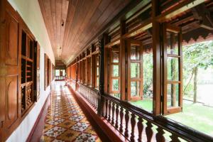 科钦Chittoor Kottaram Royal Mansion- CGH Earth的走廊上设有窗户,铺有瓷砖地板