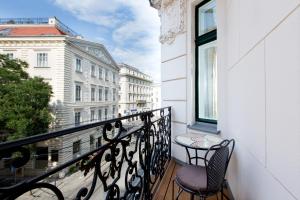 维也纳Vienna Residence, City Hall - Parliament的阳台配有两把椅子和一张桌子,还有一个窗户。