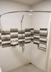 拉瓦格Hotel Lourdes的浴室设有黑色和白色条纹淋浴。