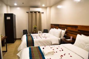 拉瓦格Hotel Lourdes的酒店客房设有两张带玫瑰花的床。