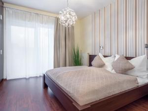 法克湖Alpe Adria Apartments - Top 1 by S4Y的一间卧室配有一张大床和一个吊灯。