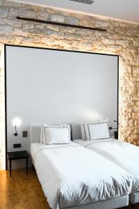 利马索尔S Paul City Hotel的卧室设有两张床铺和石墙