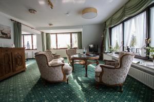 鲁尔河畔米尔海姆兰德萨森霍夫酒店的客厅配有椅子和桌子,设有窗户