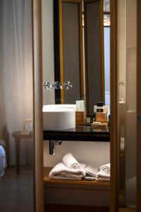 利马索尔S Paul City Hotel的浴室配有盥洗盆、镜子和毛巾