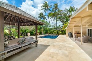 凯卢阿Kailua Beachside home的一个带游泳池和房子的户外庭院