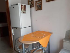 马丁纳弗兰卡La Dimora del Beato的冰箱旁的桌子上摆放着橙色毯子