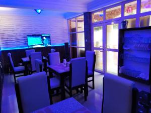 莱基Presken Hotels @ Freedom Way, Lekki的一间配备有桌子和蓝色灯光的用餐室