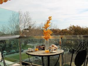 卡拉费尔Suitur beach apartment with pool的阳台上的桌子上放着橘子花瓶