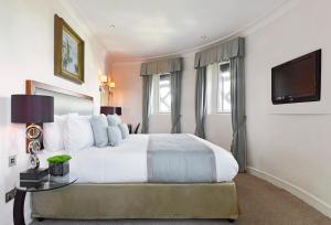 伦敦The Royal Horseguards Hotel, London的一间卧室配有一张大床和电视