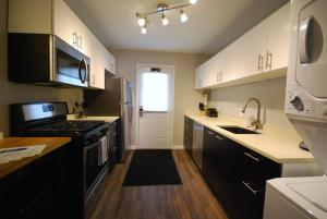 亚特兰大Brookwood Courtyard by BCA Furnished Apartments的厨房配有白色橱柜和炉灶烤箱。