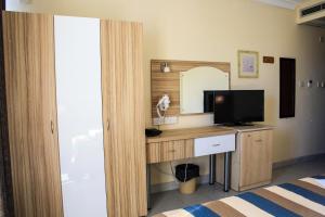 圣保罗湾城珊瑚酒店的一间卧室配有一张桌子、一台电视和一面镜子
