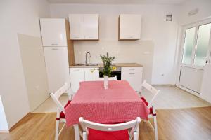 波拉斯Apartments Nodilo的厨房配有一张带红色桌布的桌子