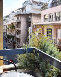 雅典Lycabettus Exclusive Apartments的从植物建筑的阳台上可欣赏到风景