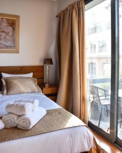 雅典Lycabettus Exclusive Apartments的一间卧室配有带毛巾的床