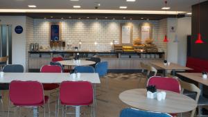 日内瓦日内瓦机场快捷假日酒店的一间带桌椅和柜台的餐厅