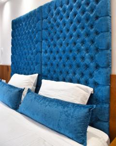 雅典Lycabettus Exclusive Apartments的蓝色垫子床头板,床上配有枕头