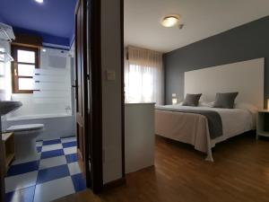 坎加斯-德奥尼斯Hotel El Trasgu的一间卧室配有一张床,浴室设有浴缸
