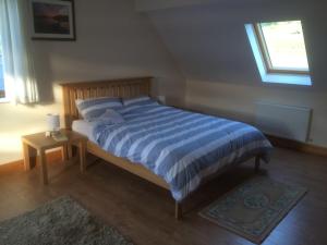 DerreenAchill Alantic Dream的卧室内的一张带蓝色和白色条纹棉被的床