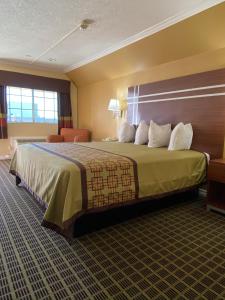 阿苏萨美洲最佳价值旅馆 - 阿祖瑟/帕萨迪纳的酒店客房配有一张带白色枕头的大床