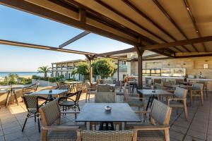 雅拉尼奥Solimar Aquamarine Resort的一个带桌椅的户外庭院和大海