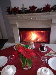 泰拉诺瓦迪波利诺B&B Tufaro Alberico的圣诞桌,壁炉,红色桌布