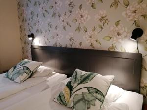 克里斯蒂安斯塔德Hotel Park Allé的卧室配有一张墙上鲜花的床