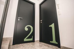 马萨纳Secret Spot Hostel的两扇带绿色数字的黑色门