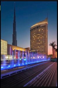 迪拜Address Dubai Mall Residences New name EMAAR Residences Fashion Avenue 1 bedroom 34 floor的前面有蓝色灯的大建筑