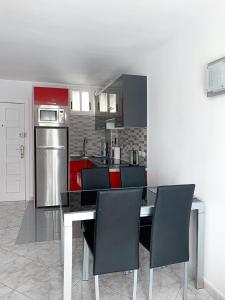 阿罗纳Apartment El Dorado, Las Americas的厨房配有桌椅和冰箱。