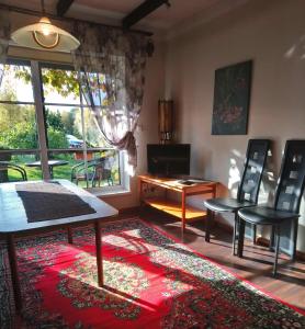 Pärispea克鲁卡度假屋的客厅配有椅子、桌子和窗户